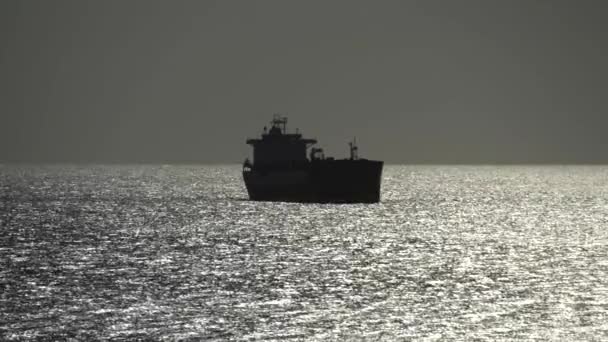 Egy hajó áll a part mellett, a nyílt tengeren, az óceánon, nyáron. Limassol, Ciprus, 4k - Felvétel, videó