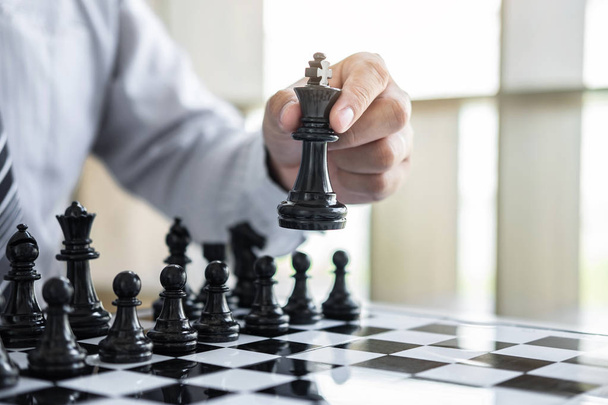 Czarno-białe szachy z graczem, Hands of businessman myślenia do przenoszenia figury szachowej w konkurencji i strategii planowania do sukcesu grać o zwycięstwo. - Zdjęcie, obraz
