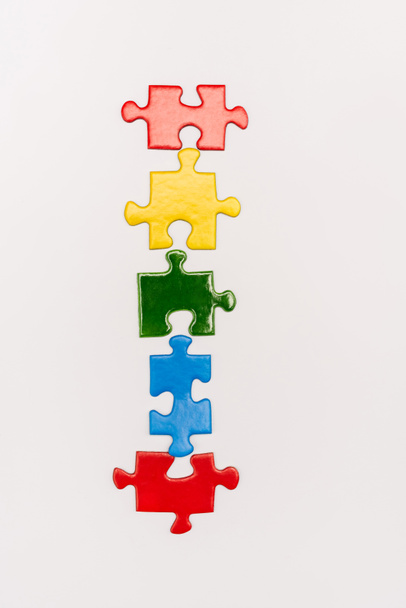 Top view of bright colorful pieces of puzzle isolated on white, autism concept - Foto, Imagen