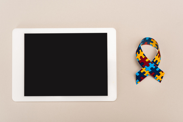 Ansicht von Awareness Ribbon und digitalem Tablet auf weißem, Autismus-Konzept - Foto, Bild