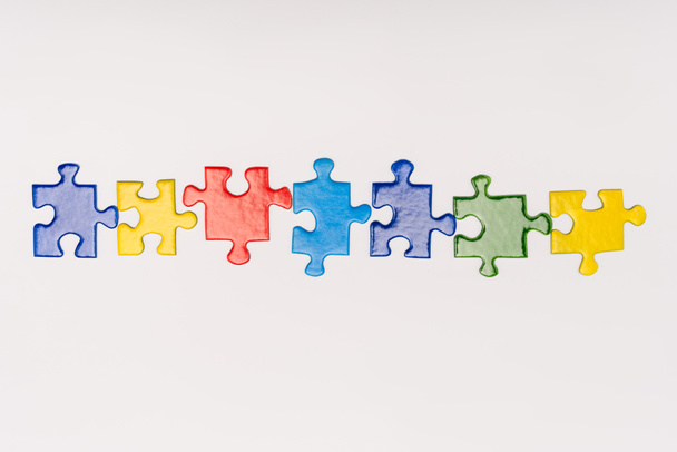 Vista dall'alto di pezzi multicolori di puzzle isolati sul bianco, concetto di autismo
 - Foto, immagini