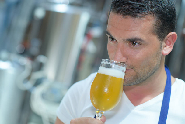 close-up of brewer smelling beer at brewery factory - Φωτογραφία, εικόνα