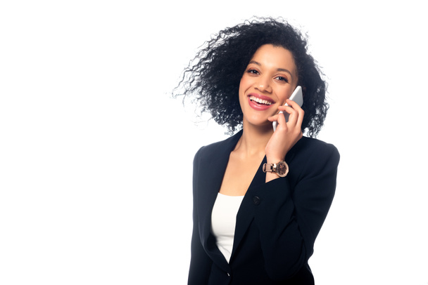 Successful african american businesswoman talking on smartphone, smiling and looking at camera isolated on white - Fotoğraf, Görsel