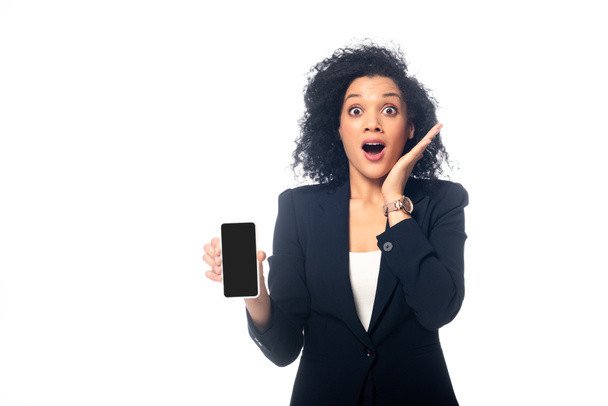 Front view of shocked african american woman with smartphone isolated on white - Foto, Bild