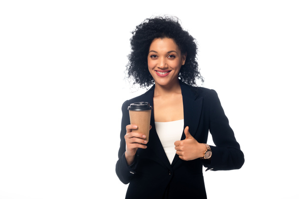 Vista frontal de afroamericano con taza de café desechable sonriendo y mostrando el pulgar hacia arriba aislado en blanco
 - Foto, imagen