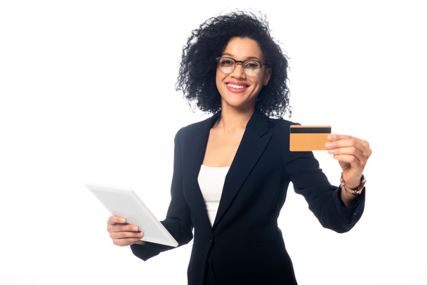 Африканська бізнесменка з Америки тримає цифрову табличку, посміхаючись і показуючи кредитну картку ізольовану на білому - Фото, зображення