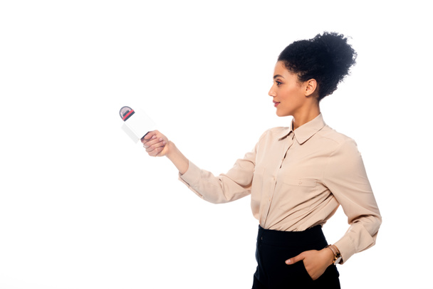 Journaliste afro-américain avec la main dans la poche tenant le microphone dans la main tendue isolé sur blanc
 - Photo, image