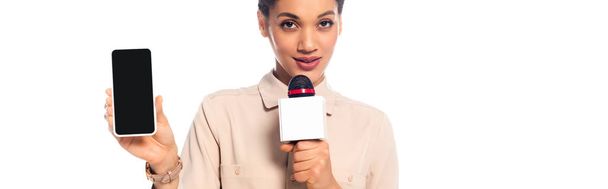 Afrikkalainen amerikkalainen toimittaja puhuu mikrofoniin ja esittää älypuhelimen eristetty valkoinen, panoraama ammuttu
 - Valokuva, kuva
