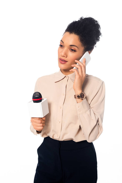 Jornalista afro-americano atencioso com microfone falando em smartphone isolado em branco
 - Foto, Imagem