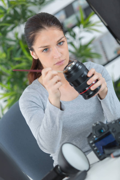 photographer cleans the front of the lens on the camera - Foto, Bild