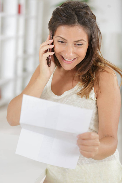 portrait of confident happy woman on phone reading a letter - Foto, Imagen