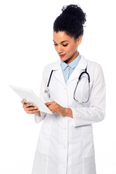 Vooraanzicht van Afrikaanse Amerikaanse arts met stethoscoop met behulp van digitale tablet geïsoleerd op wit - Foto, afbeelding