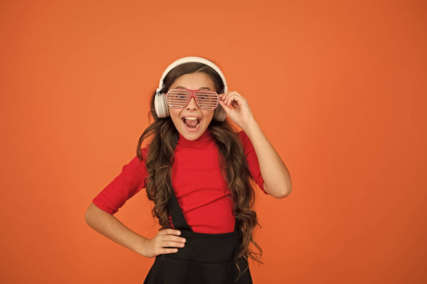 Enjoying music playing on DJ party. funny child in party glasses. time for having fun. modern kid enjoy music. stylish and confident. school radio dj. small happy girl listen music in headphones - Foto, imagen