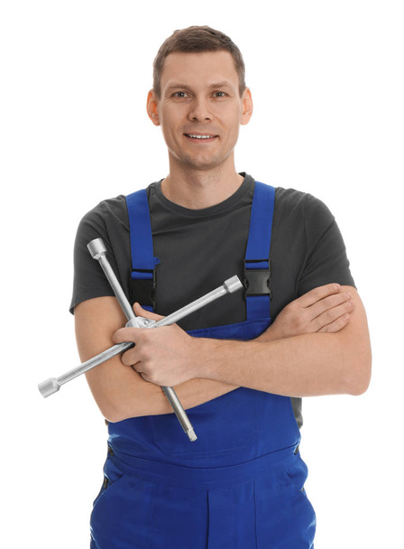 Portrait of professional auto mechanic with lug wrench on white background - Foto, immagini
