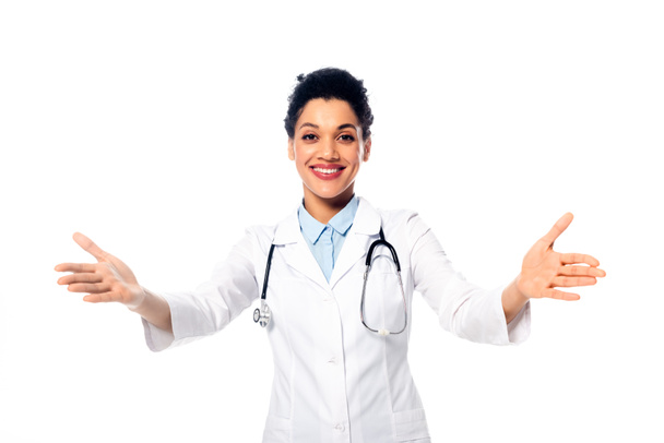 Afrikai amerikai orvos sztetoszkóppal és nyitott karokkal, fehér alapon izolált mosollyal. - Fotó, kép