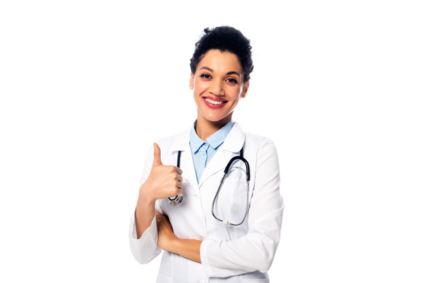 Front view of african american doctor with stethoscope showing like with thumb up and smiling isolated on white - Foto, afbeelding