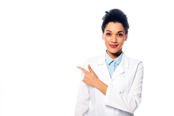 Front view of african american doctor looking at camera, smiling and pointing with finger isolated on white - Φωτογραφία, εικόνα