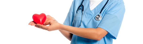 Vue recadrée d'une infirmière afro-américaine avec stéthoscope montrant un cœur décoratif isolé sur une photo panoramique blanche
 - Photo, image