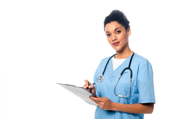 African american nurse with stethoscope writing on clipboard isolated on white - Foto, Bild