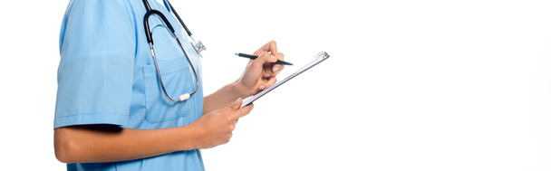 Vista recortada de la enfermera afroamericana escribiendo en el portapapeles y sonriendo aislado en blanco, plano panorámico
 - Foto, imagen