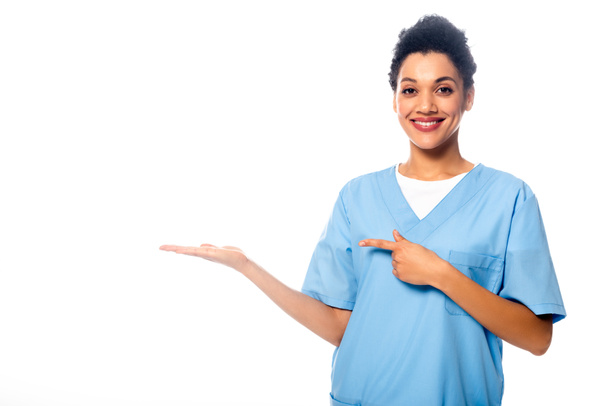 Африканська американська медсестра посміхається і вказує пальцем на білому - Фото, зображення
