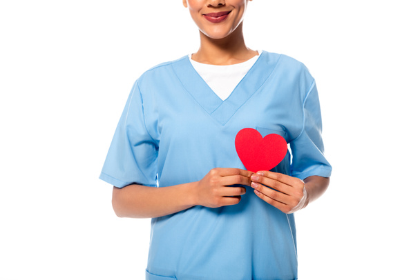 Vue recadrée de l'infirmière afro-américaine présentant coeur décoratif isolé sur blanc
 - Photo, image