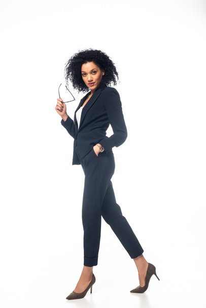 Visão de comprimento total da bela mulher de negócios afro-americana com a mão no bolso no branco
  - Foto, Imagem