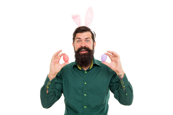 Celebration of spring holiday. Bearded man with bunny ears and Easter eggs. Hipster with long ears holding egg. Culture customs and traditions. Easter bunny delivering colored eggs. Seasonal goods - Foto, Bild