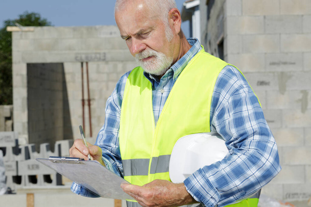 a senior man with a clip board -health and safety - Photo, Image