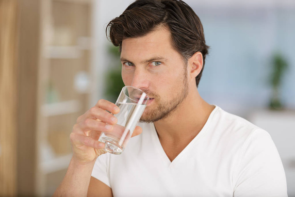 morning of handsome young man drinking water at home - Φωτογραφία, εικόνα