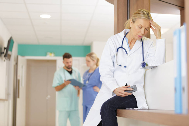 stressed female doctor holding smartphone - Foto, immagini