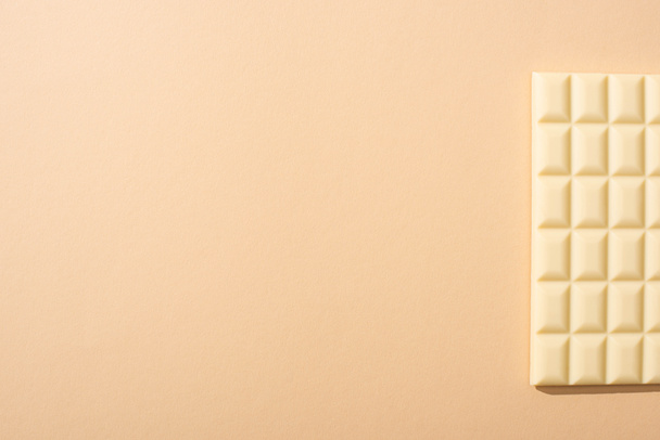 top view of delicious white chocolate bar on beige background - Foto, afbeelding