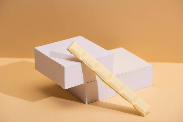délicieux morceau de chocolat blanc et cubes sur fond beige
 - Photo, image
