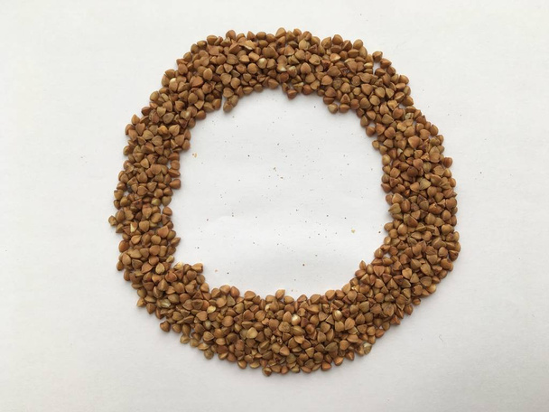 Buckwheat grains laid out in the shape of a ring. Abstract art. Minimalism. - Photo, Image