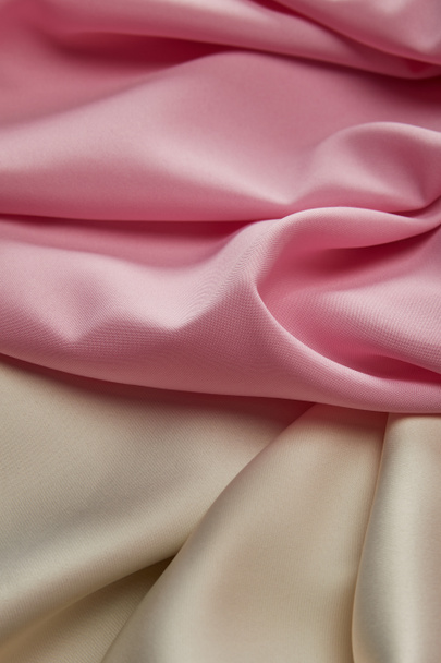 close up view of satin pink and white soft and wavy fabric - Foto, afbeelding
