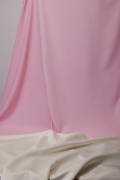 στενή άποψη του ροζ και άσπρο μαλακό και κυματιστό ύφασμα που απομονώνονται σε γκρι - Φωτογραφία, εικόνα