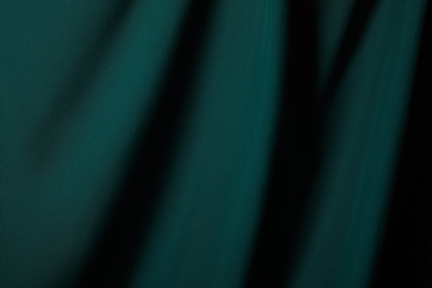 close up view of emerald soft and wavy silk fabric - Foto, afbeelding