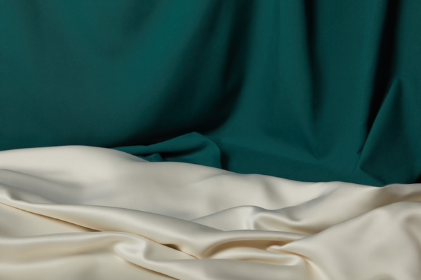 close up view of emerald and white soft and wavy silk fabric - Foto, afbeelding