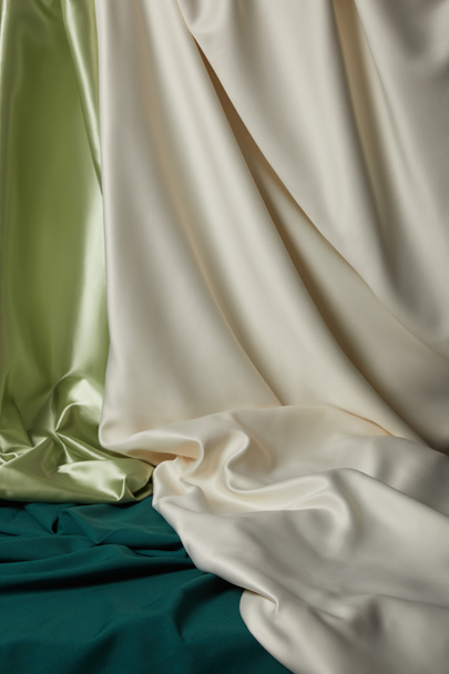 close up view of emerald, light green and white soft and wavy silk fabric - Zdjęcie, obraz