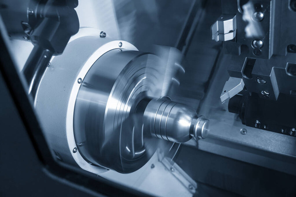 Maszyna tokarka CNC w procesie obróbki metalu tworząc cięcia części wałów metalowych z w jasnoniebieskiej scenie. Wysokowydajna obróbka metali przez tokarkę CNC . - Zdjęcie, obraz