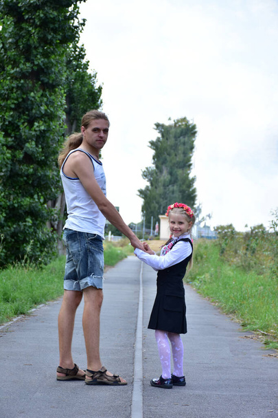 Vater und Tochter gehen mit dem Rücken zur Straße, - Foto, Bild
