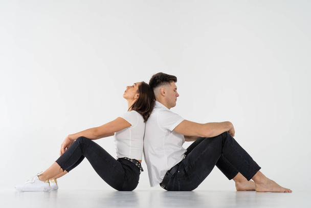 Pensive man and woman sitting back to back after quarrel on white background. copy space  - Foto, Imagen