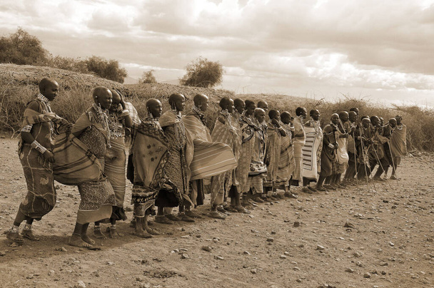 АМБОСЕЛИ, КЕНЯ - 13 октября 2011 года группа неизвестных африканских мужчин из племени Масаи готовится показать традиционный танец джампа в Масаи Мара, Кения. Они кочевые и живут в маленьких деревнях.. - Фото, изображение