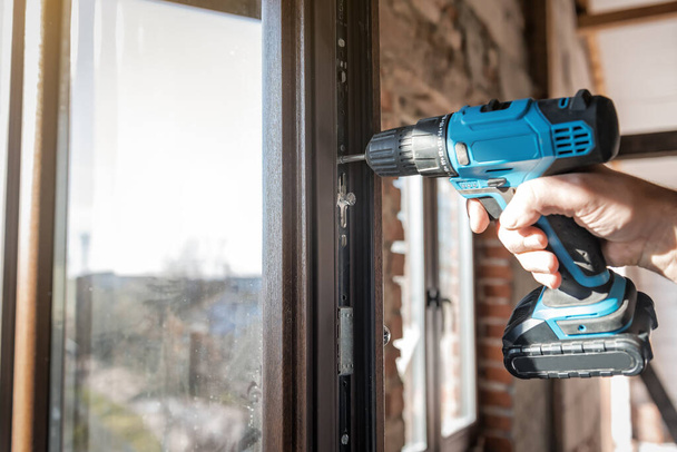 worker with professional electric screwdriver adjusts the window - Fotografie, Obrázek