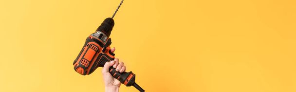 panoramic shot of woman holding drill on yellow background  - Photo, Image