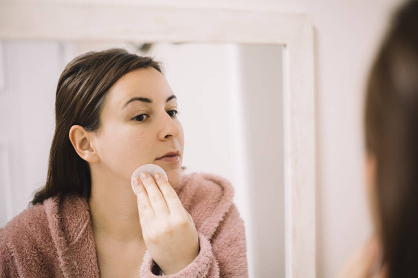 Woman removing makeup using a cotton pad - Foto, Imagen