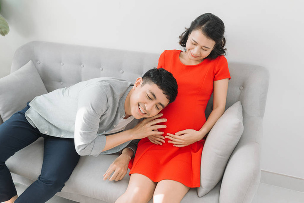 молодая беременная женщина с мужем, ожидающим ребенка
 - Фото, изображение