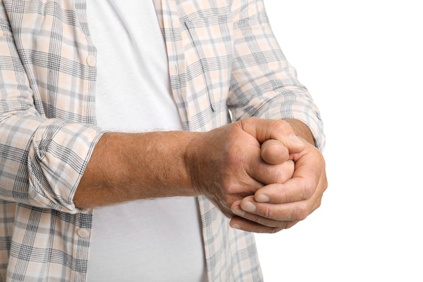 Vanhempi mies, joka kärsii Parkinsonin oireyhtymästä valkoisella taustalla, lähikuva
 - Valokuva, kuva