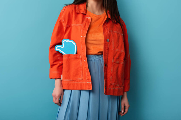 cropped view of woman with paper like in jacket on blue background  - Foto, afbeelding