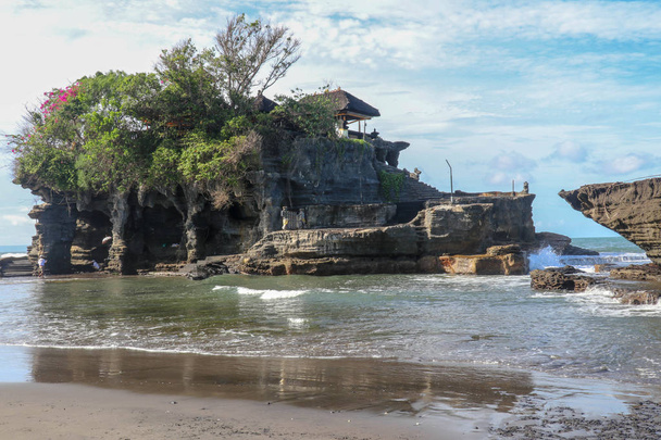 Όμορφο βαλινέζικο τοπίο. Αρχαίος ινδουιστικός ναός Tanah πολύ στο βράχο ενάντια στον ουρανό ηλιοβασιλέματος. Νήσος Μπαλί, Ινδονησία. διάσημο ναό Tanah Lot στη θάλασσα στο νησί Μπαλί της Ινδονησίας με μπλε ουρανό και τα κύματα. - Φωτογραφία, εικόνα